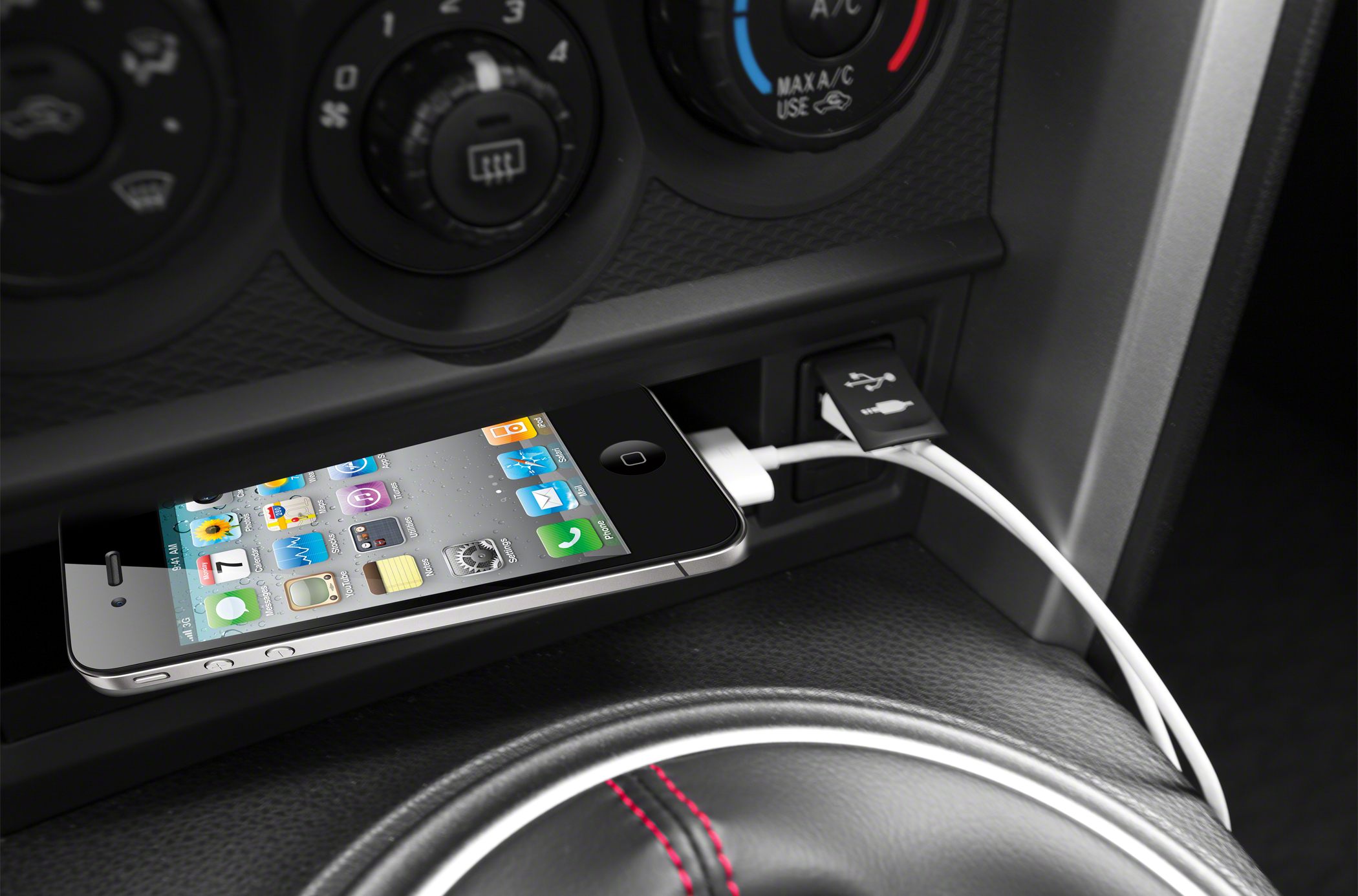 USB charging port with smartphone and climate control knobs