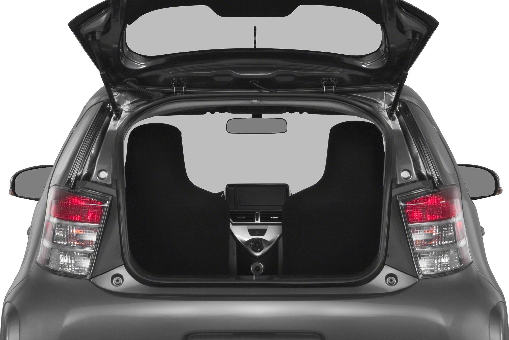 Open rear hatch revealing compact hatchback rear and interior front seats with dashboard.