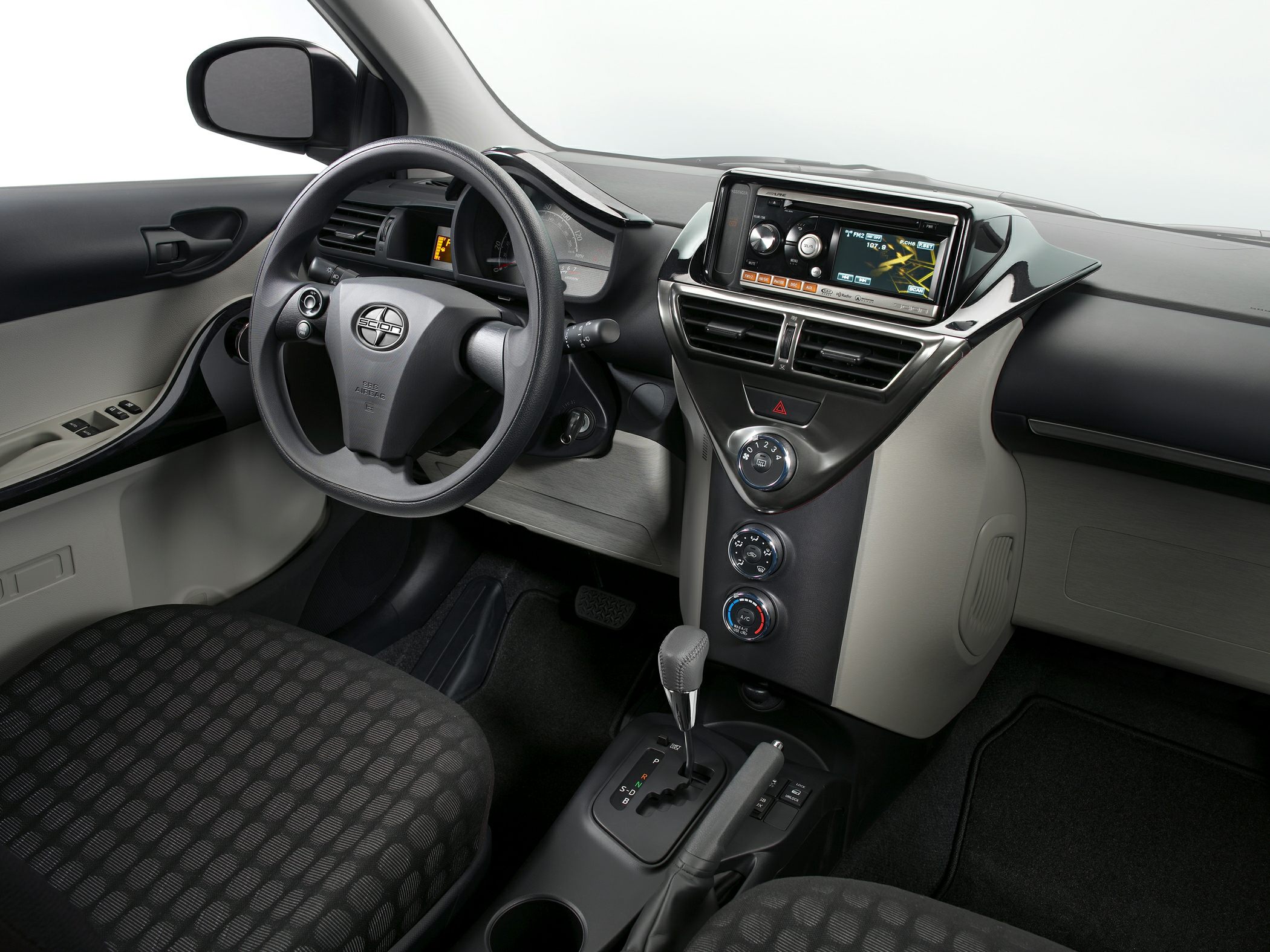 Dashboard controls, steering wheel, gear selector in compact car interior