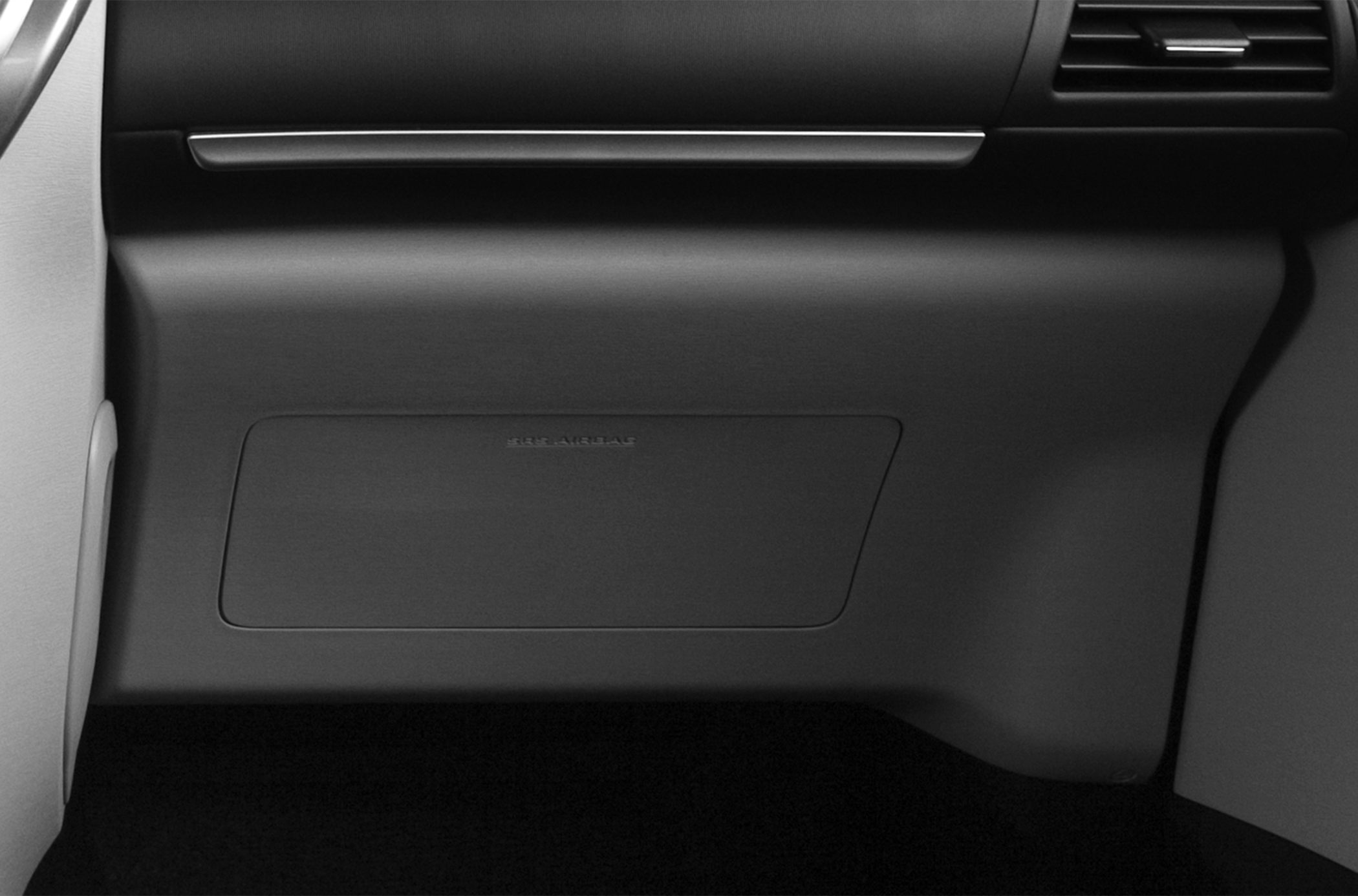Close-up of glove compartment and dashboard with SRS airbag panel.