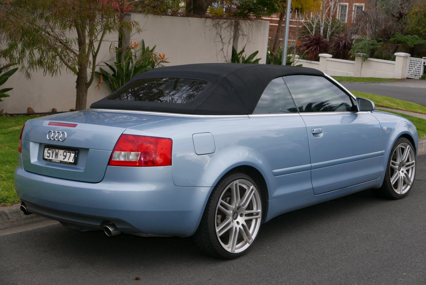 Rear and side view of convertible with closed soft top and alloy wheels