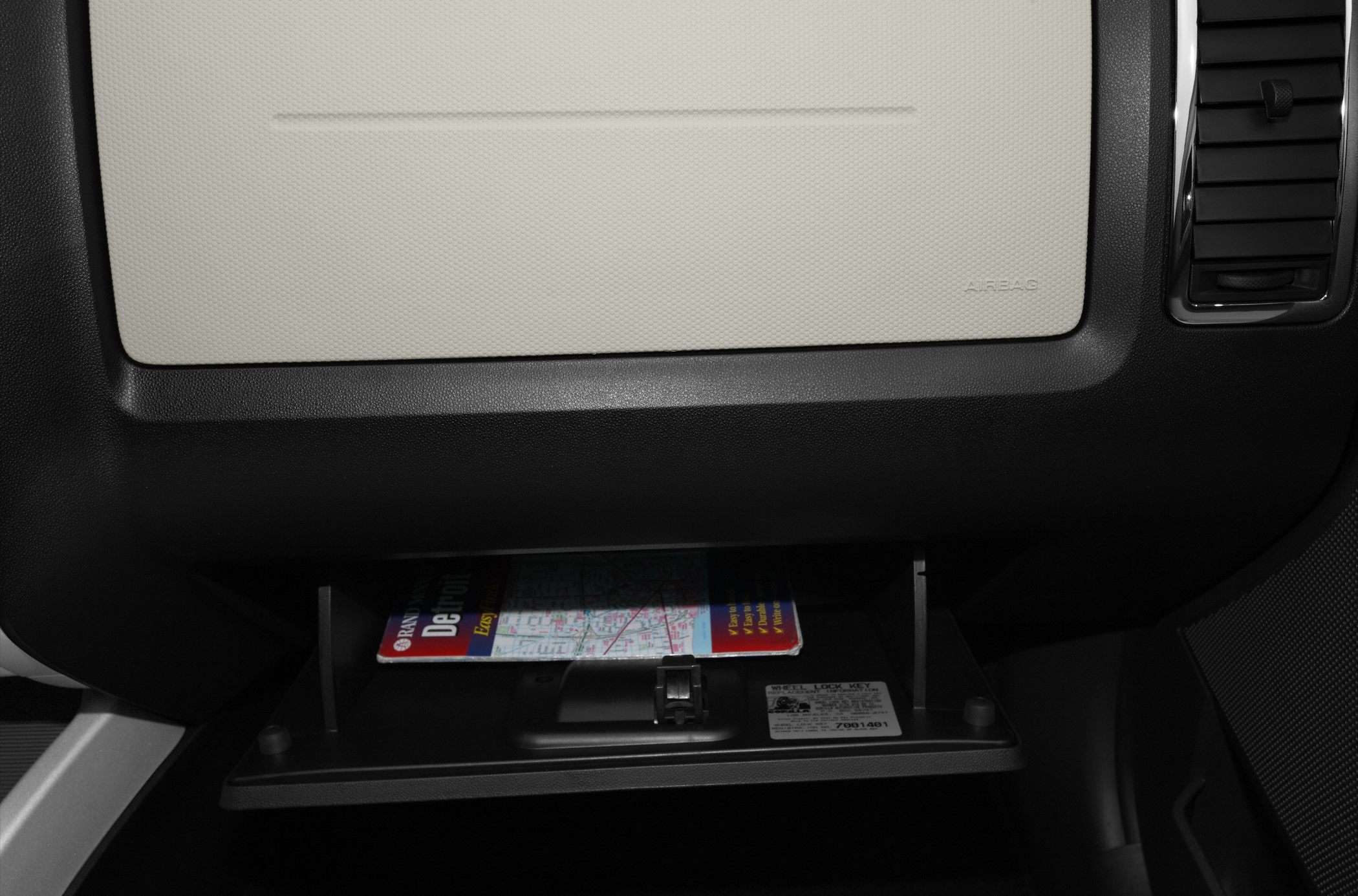 Open glove compartment with map inside vehicle dashboard