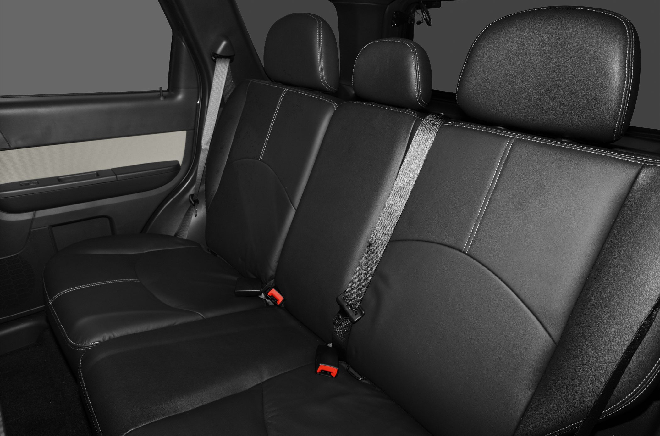 Black leather rear seat with three headrests and seatbelts