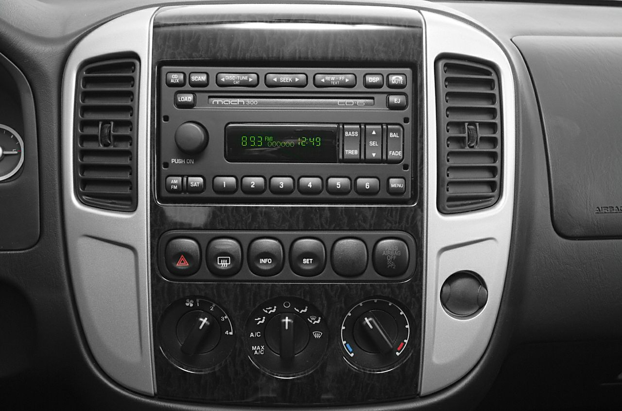 Car dashboard with audio system, air vents, and climate control knobs