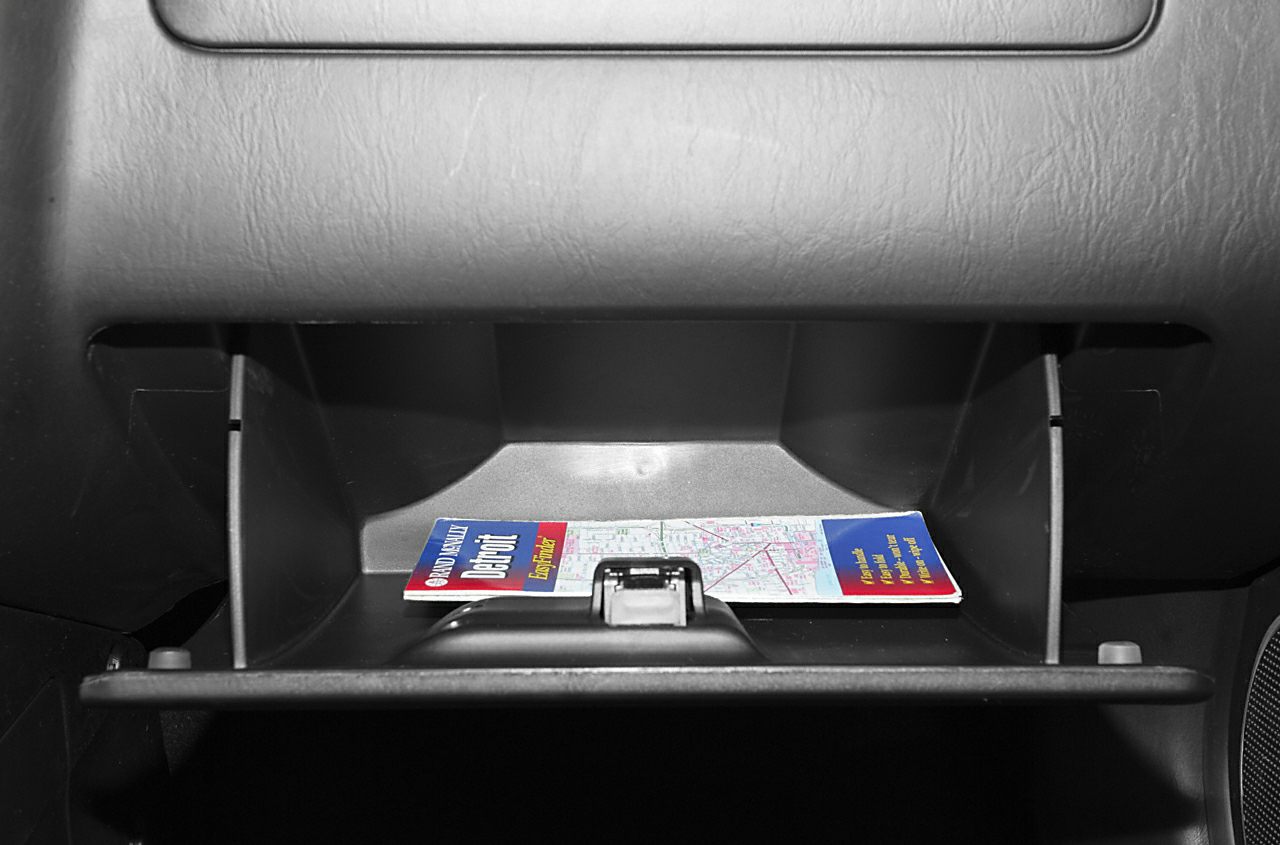 Open car glove box with a folded map inside