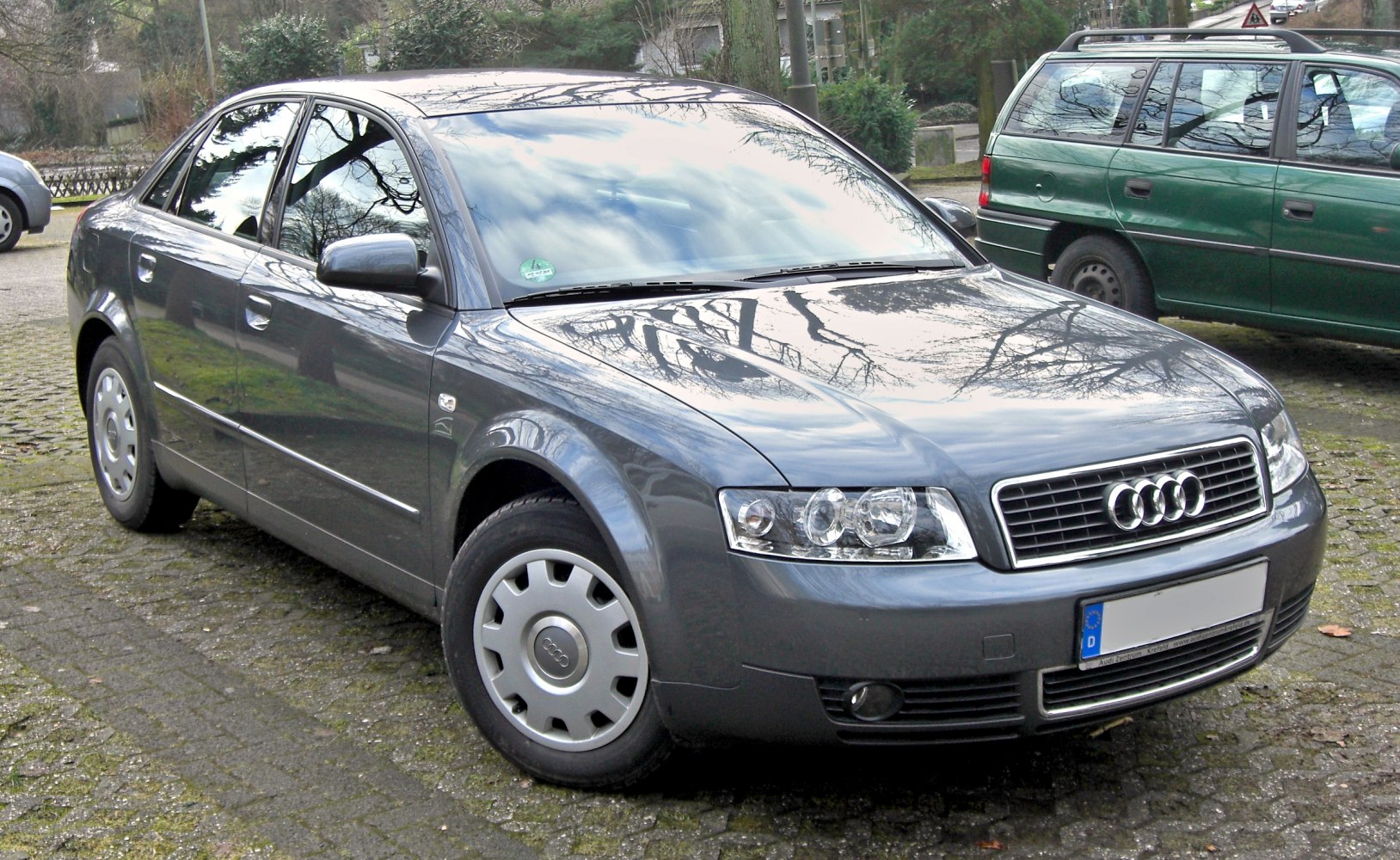 Front and side view of a 4-door sedan with clear grille and headlamps