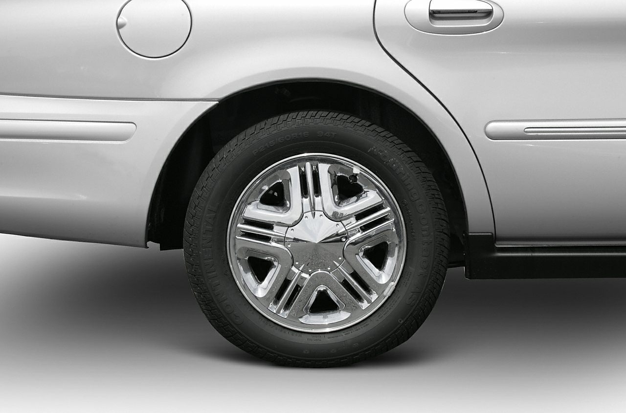 Close-up of chrome alloy wheel and rear side panel with fuel cap.