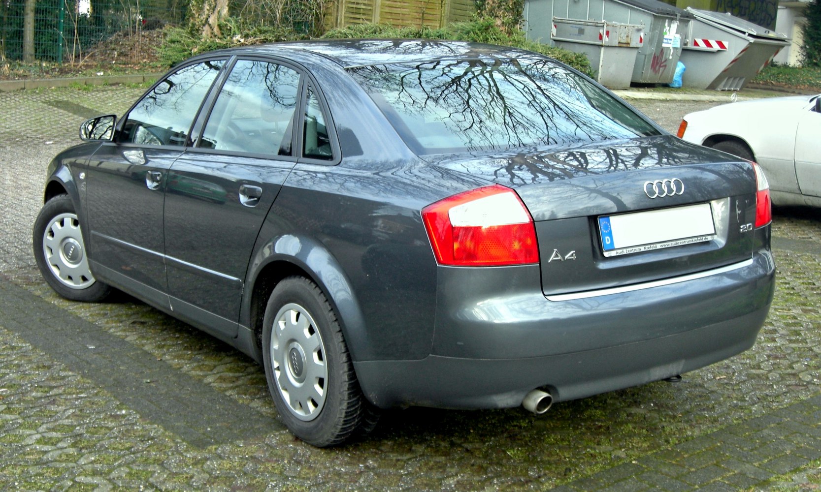 Rear and side profile of a dark gray sedan with distinctive taillights.
