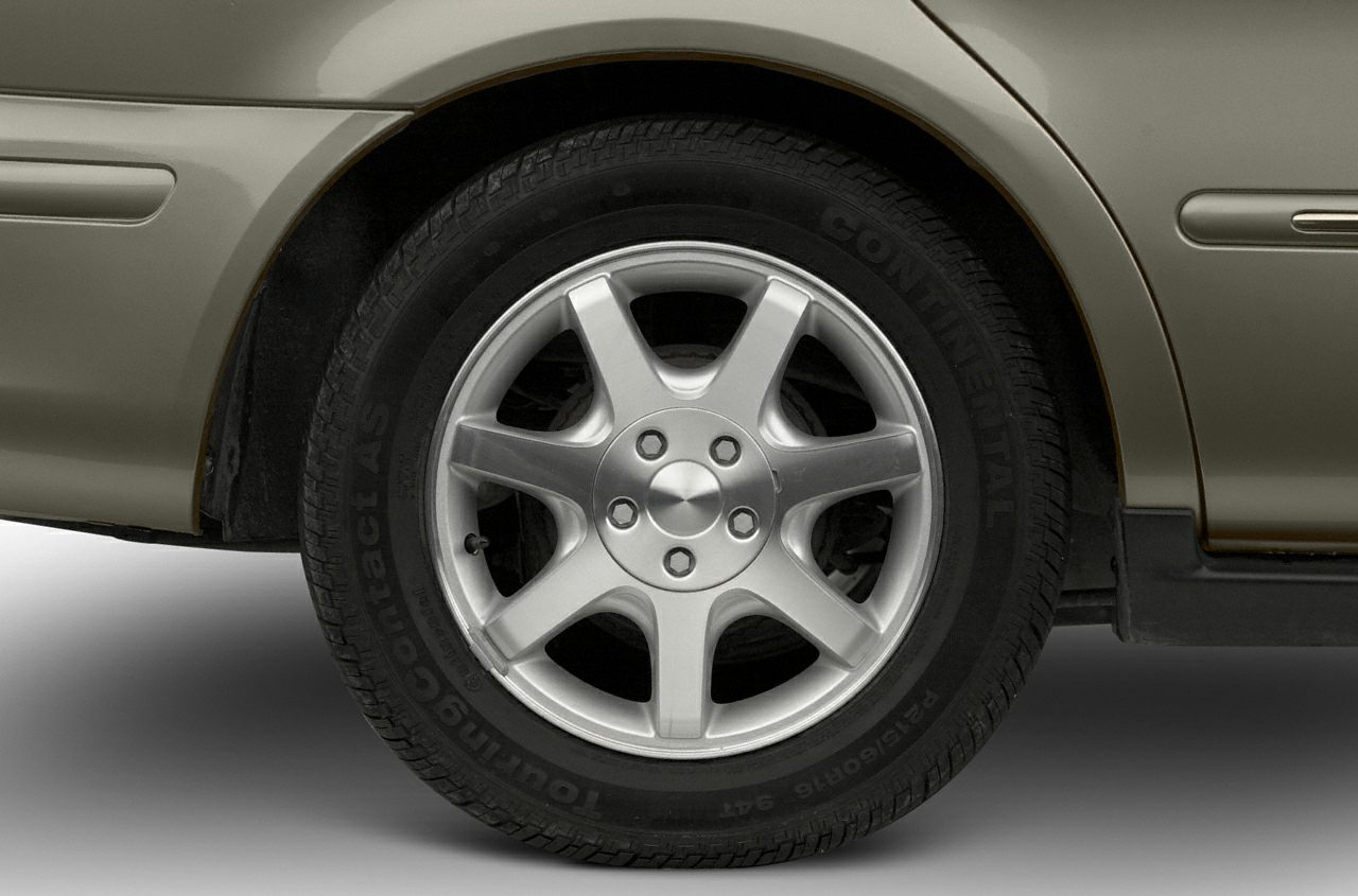 Alloy wheel and Continental TouringContact tire on car rear.