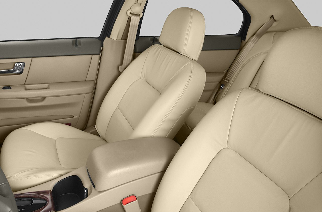Tan leather front and rear seats with seatbelt and center console details