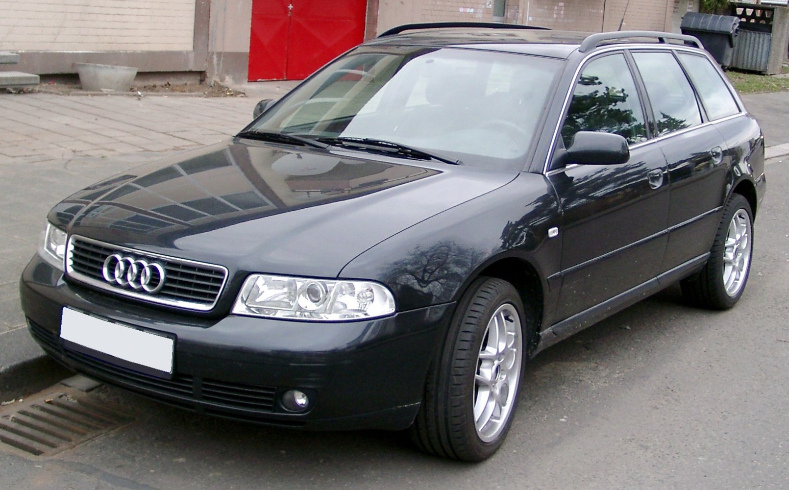 Black station wagon with alloy wheels and roof rails front side angle.