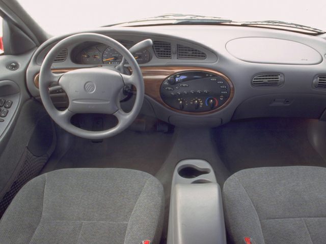Dashboard and steering wheel with central controls and wood trim