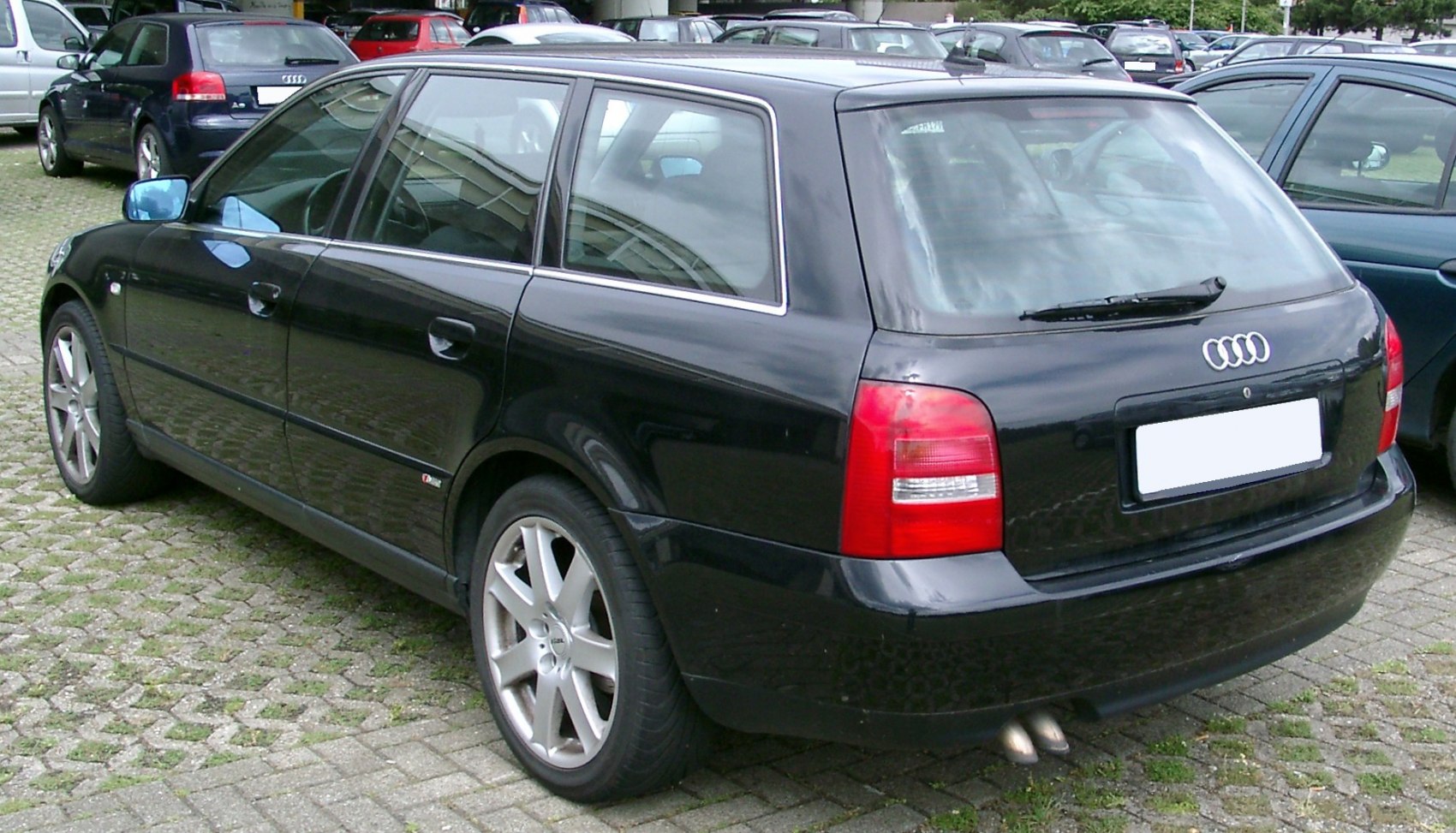 Rear side view of a black wagon with alloy wheels and chrome window trim.