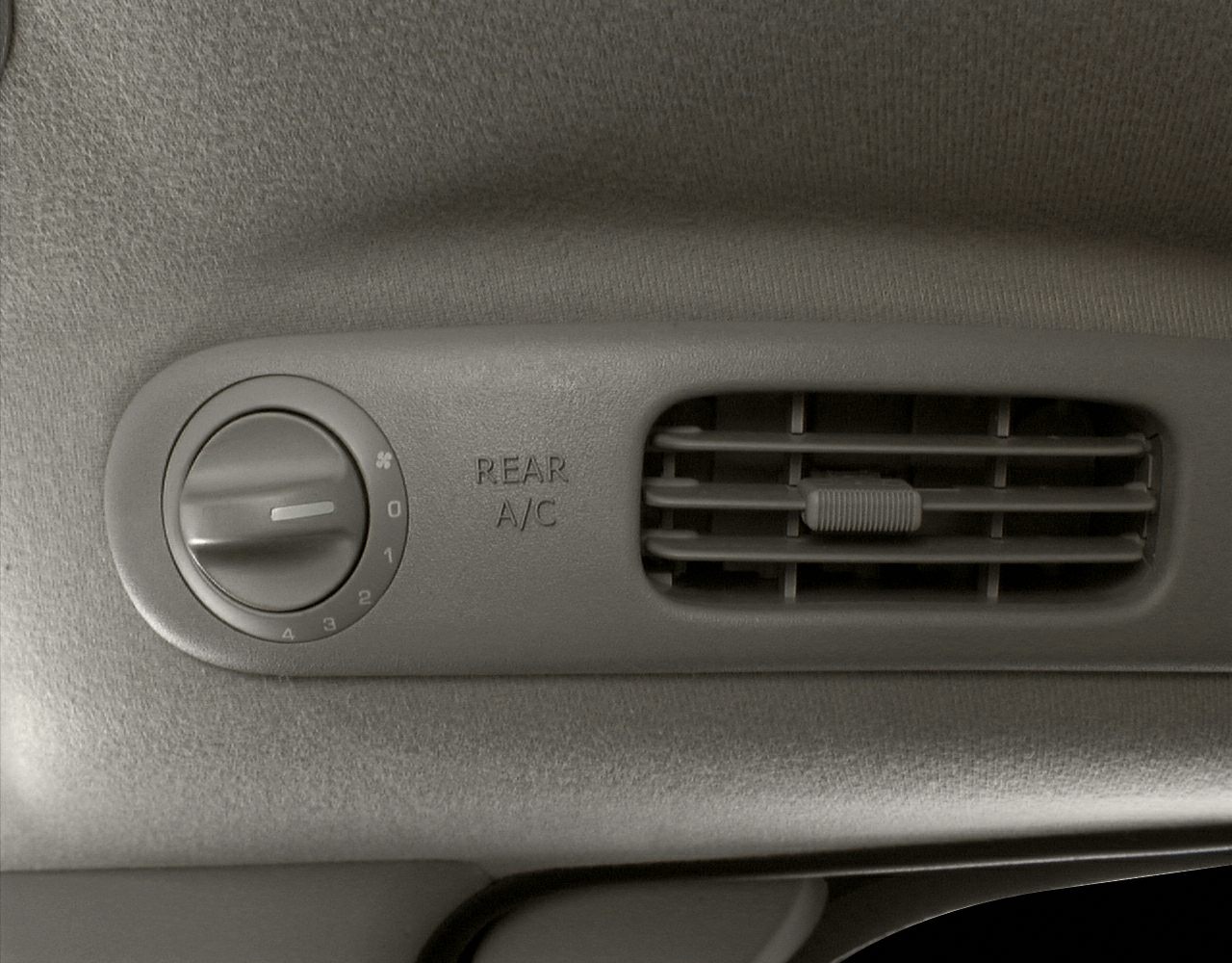 Rear air conditioning vent and control knob for rear A/C airflow adjustment.