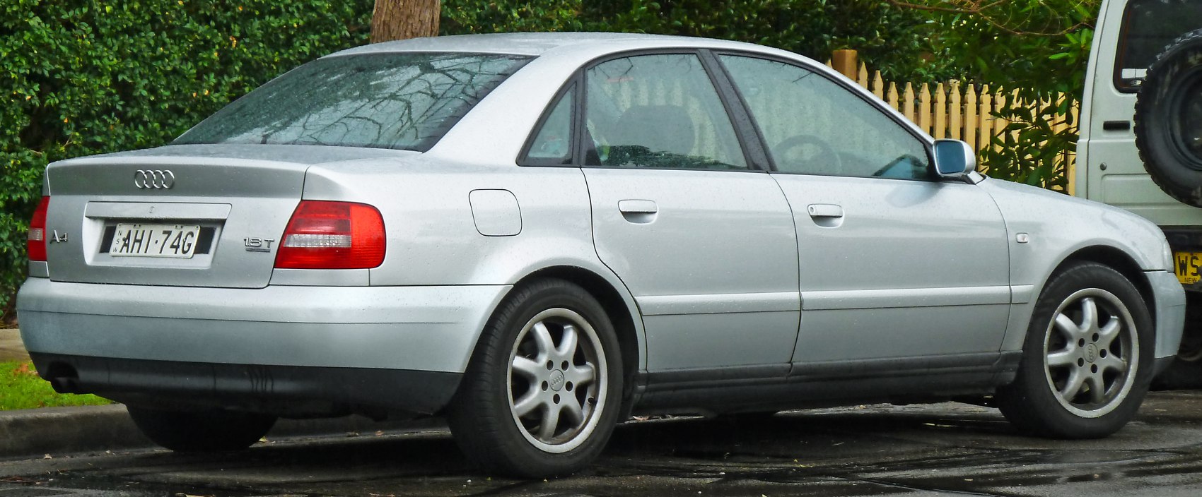 Silver sedan rear side profile with alloy wheels and tail lights