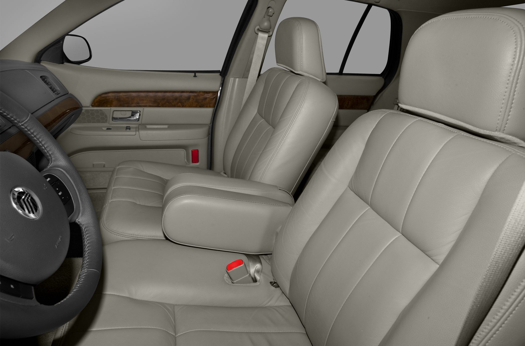 Beige leather front seats with armrest and wood grain door trim