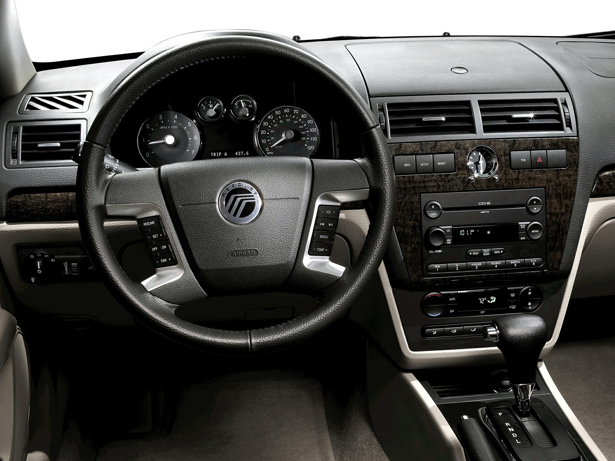 Steering wheel with controls, dashboard with analog gauges, and center console with radio and climate control.