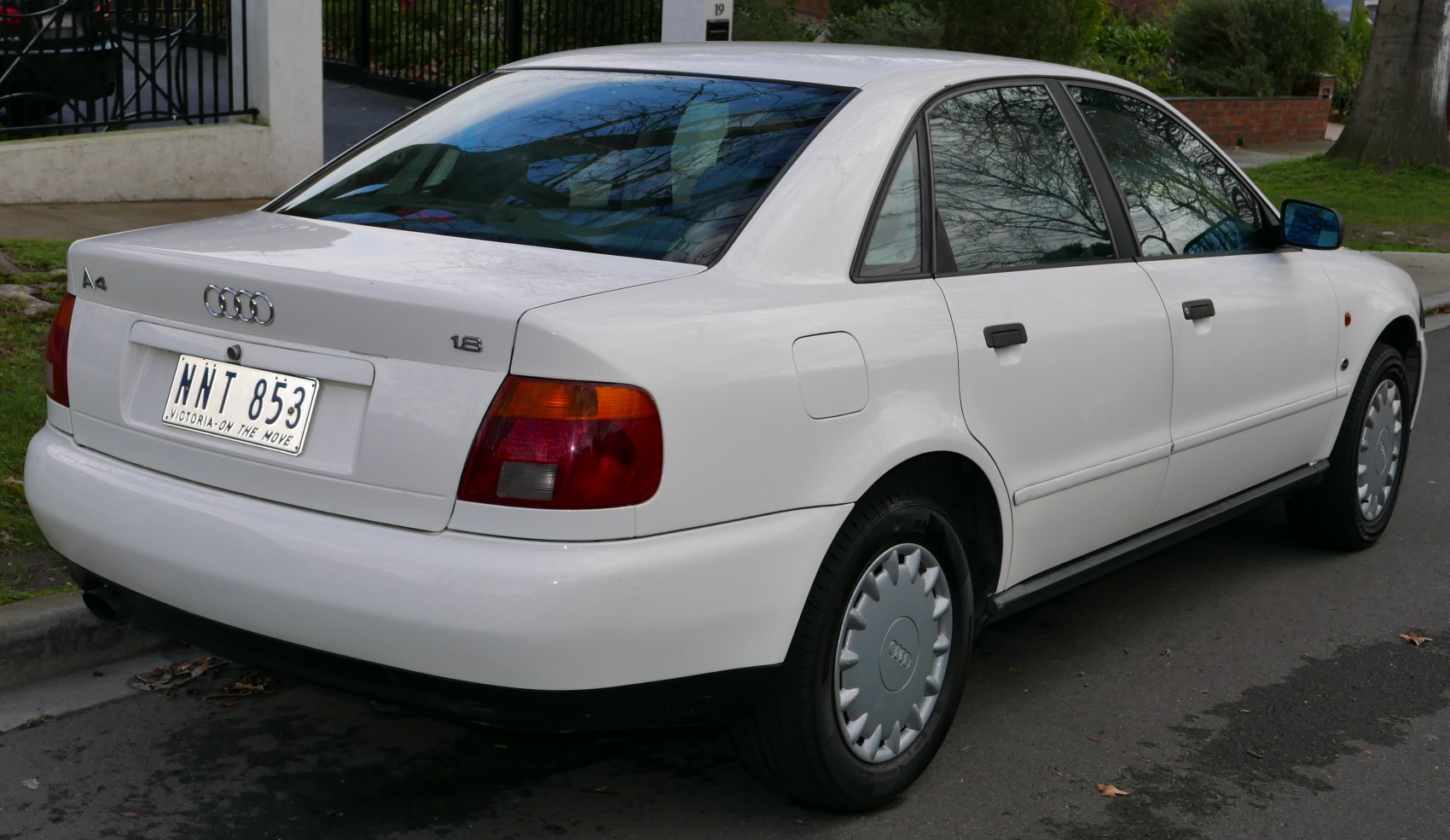Rear side view of a 1995 sedan with classic tail lights and smooth white lines