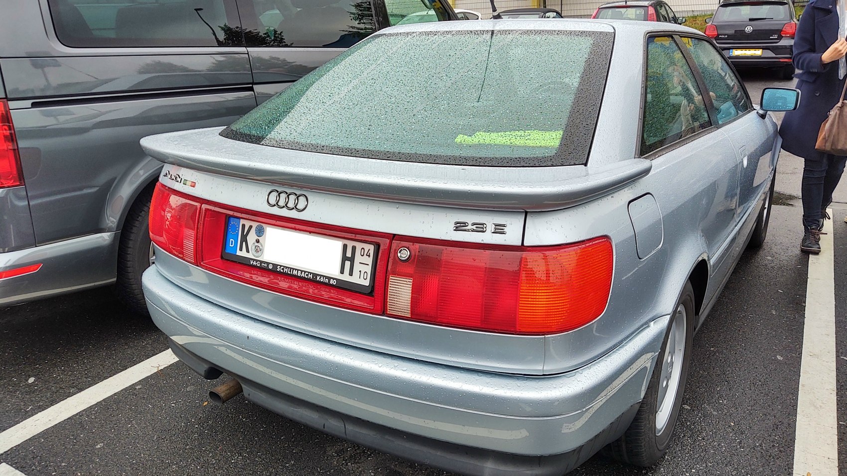 Rear view of silver coupe with rear spoiler and red light bar
