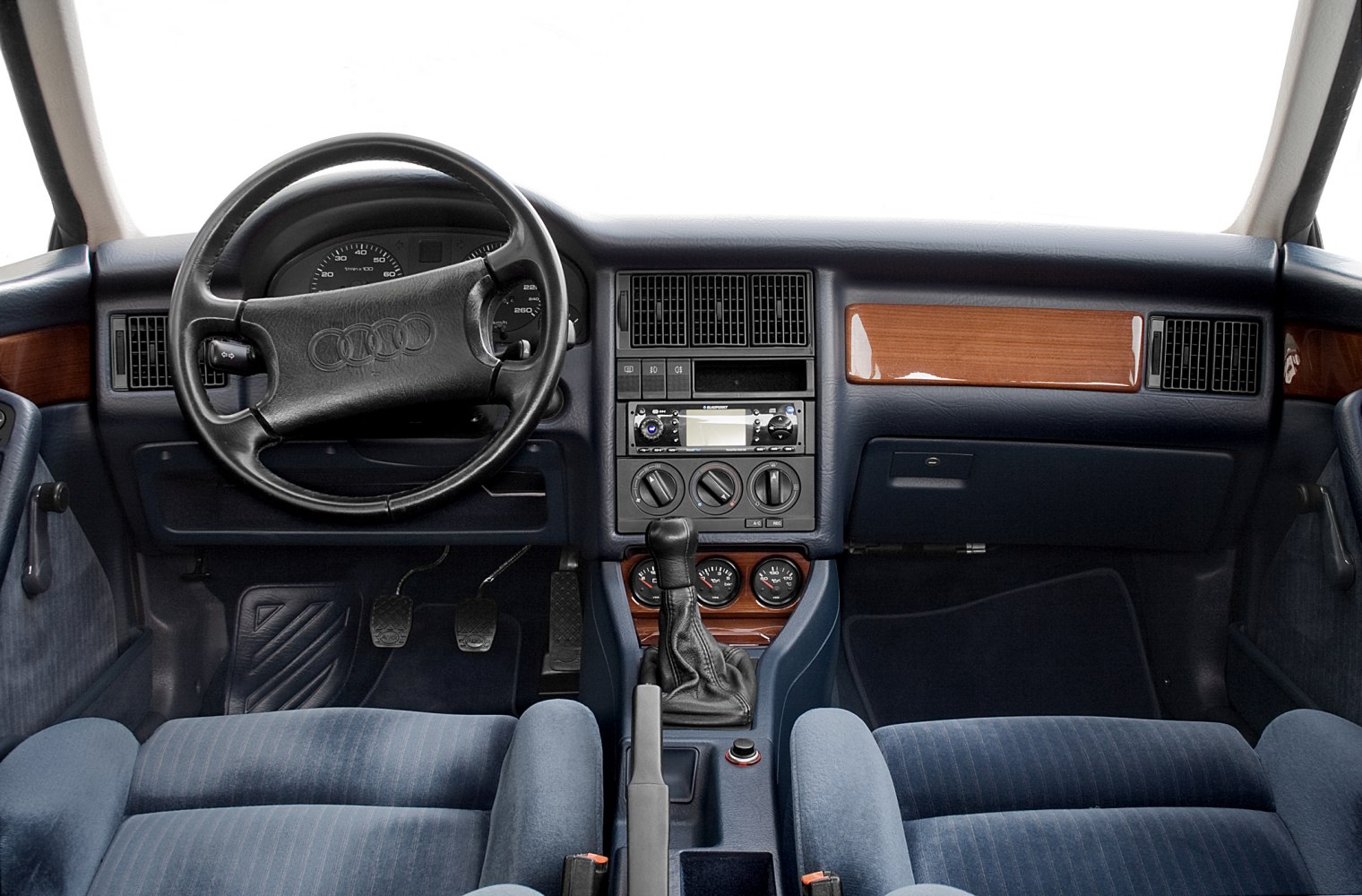 Dashboard, steering wheel, wooden trim, manual gear shift, blue upholstery