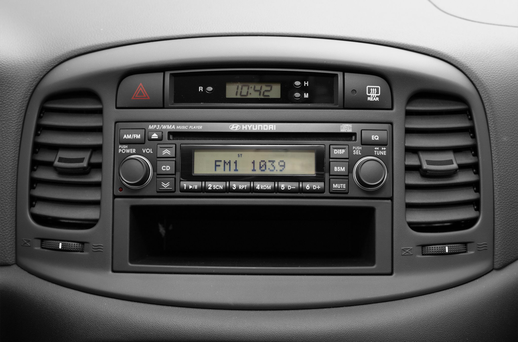 Close-up of car dashboard radio and air vents.