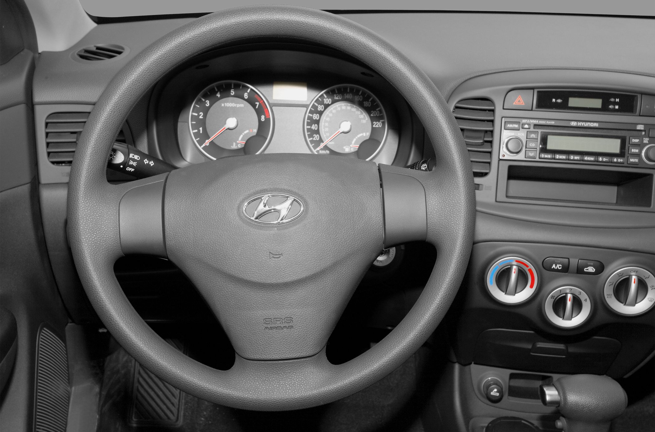 Steering wheel, instrument cluster, dashboard controls with air conditioning and radio.