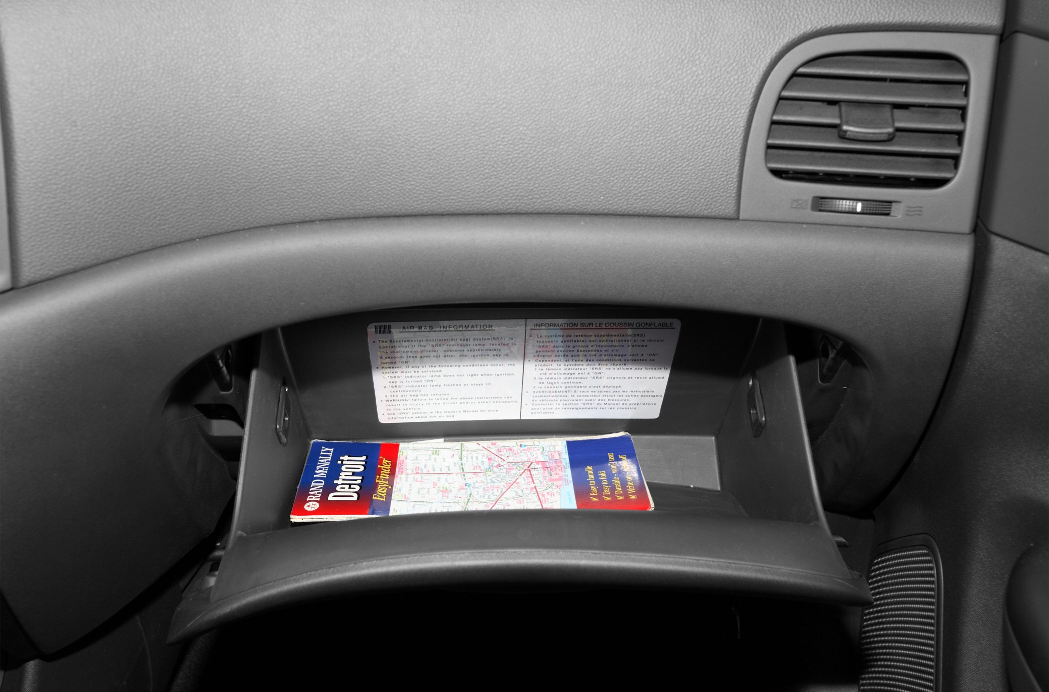 Open glove compartment with map and airbag information label
