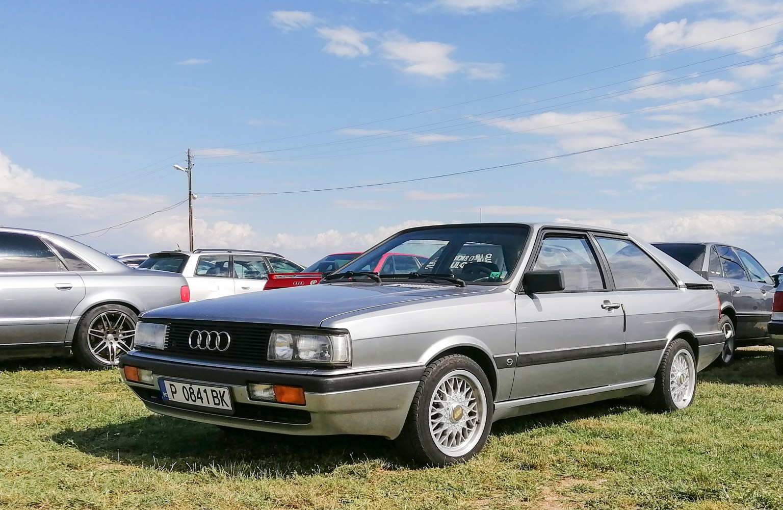 Silver 1980s coupe with boxy design and alloy wheels
