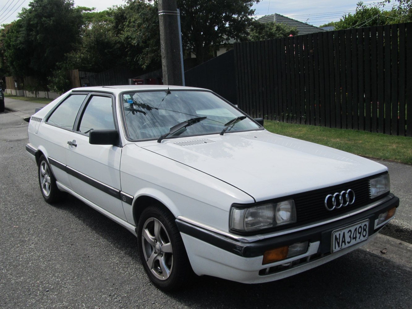 Front-side view of vintage coupe with rectangular headlights and classic grille