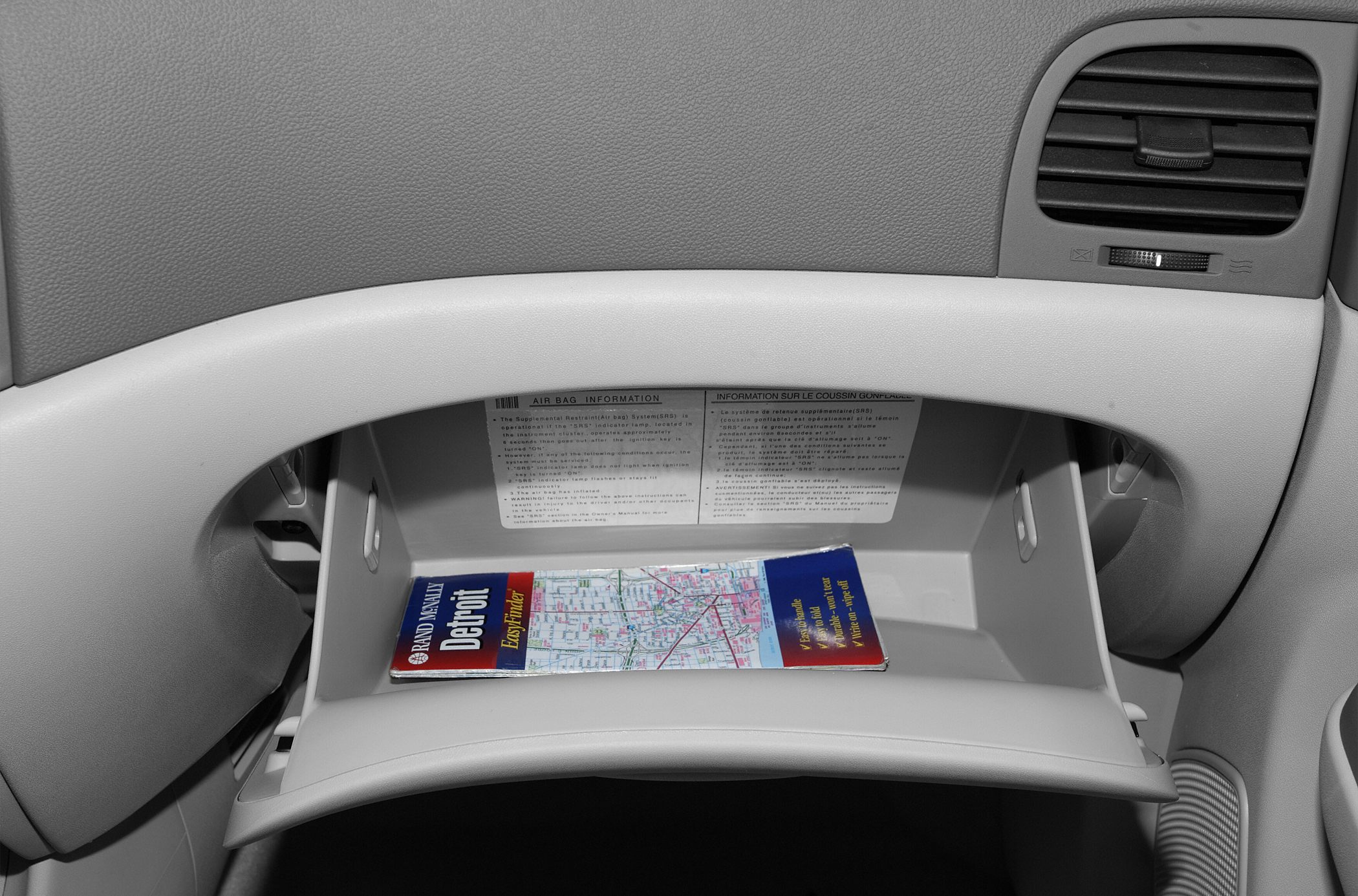 Open glove compartment with interior storage and air vent