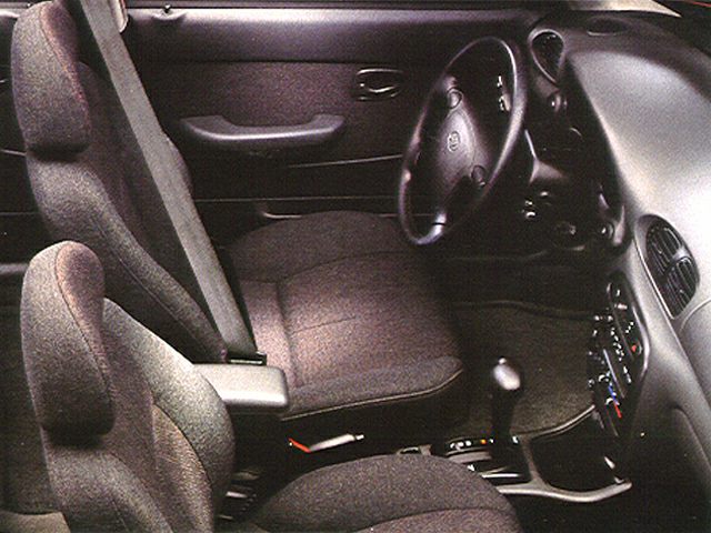 Fabric-upholstered front seats with steering wheel and dashboard controls in car interior