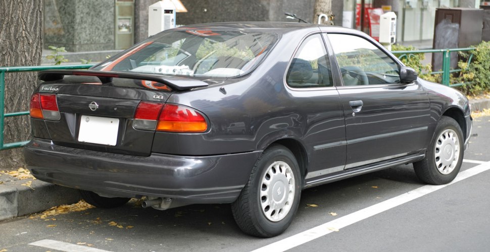 Rear side view of compact coupe with spoiler and classic design
