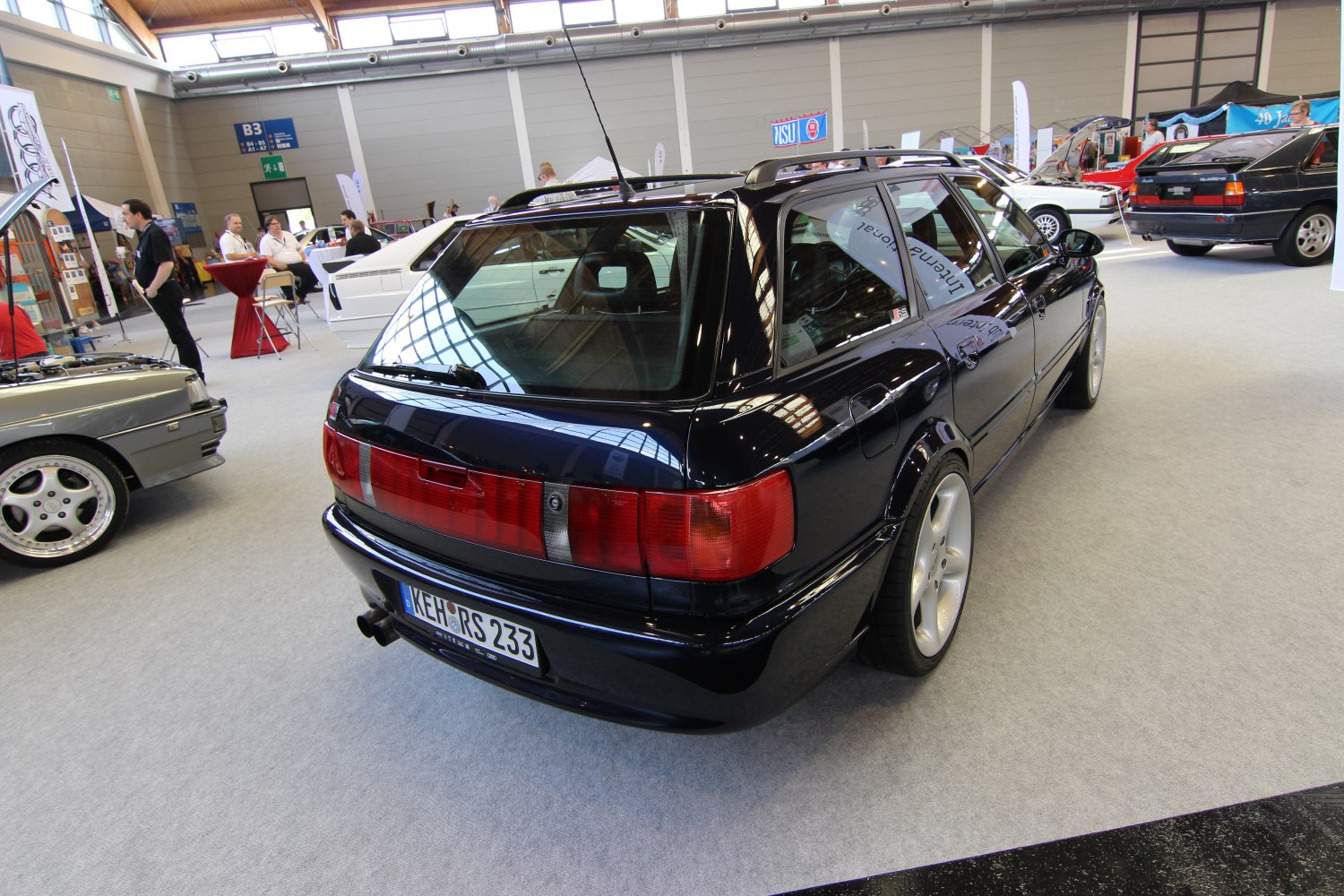Wide body estate car rear with distinctive red tail lights and five-spoke wheels