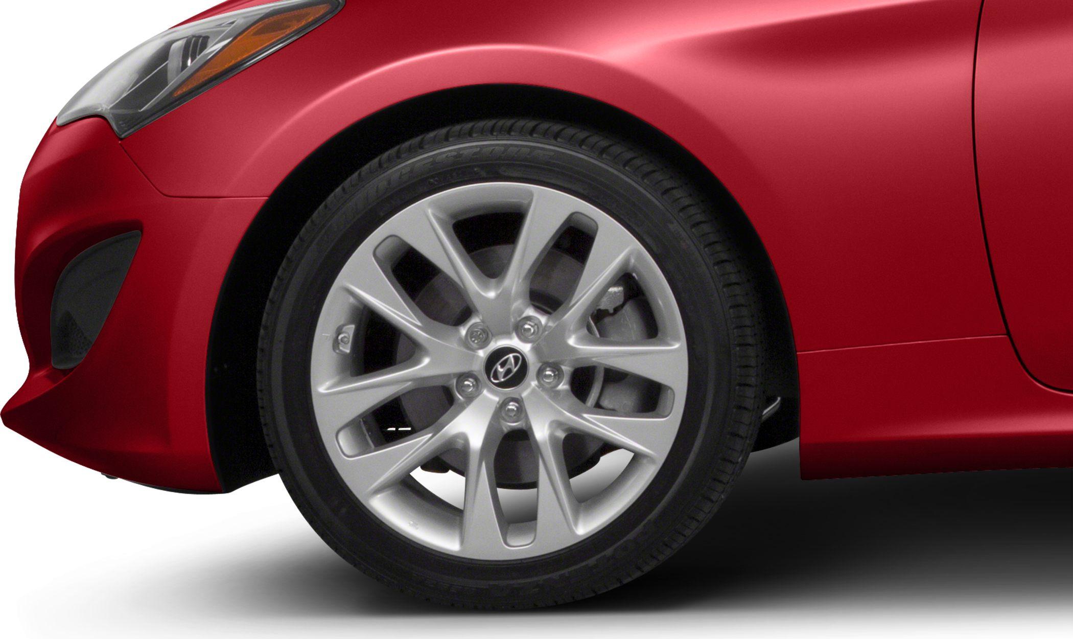 Front alloy wheel and side panel of a coupe in red