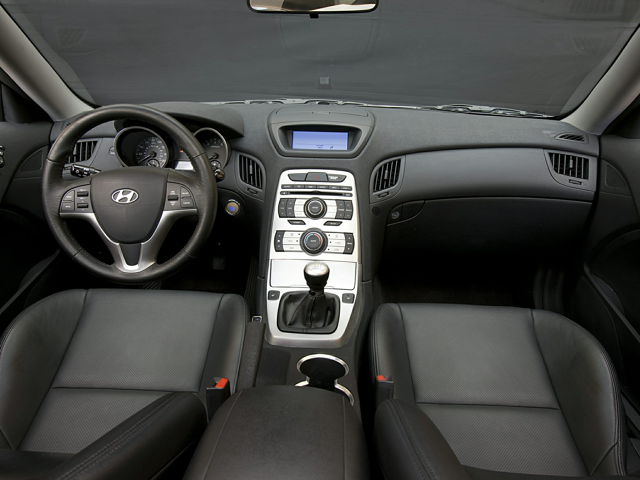 Dashboard, manual gear shift, and steering wheel controls in car interior