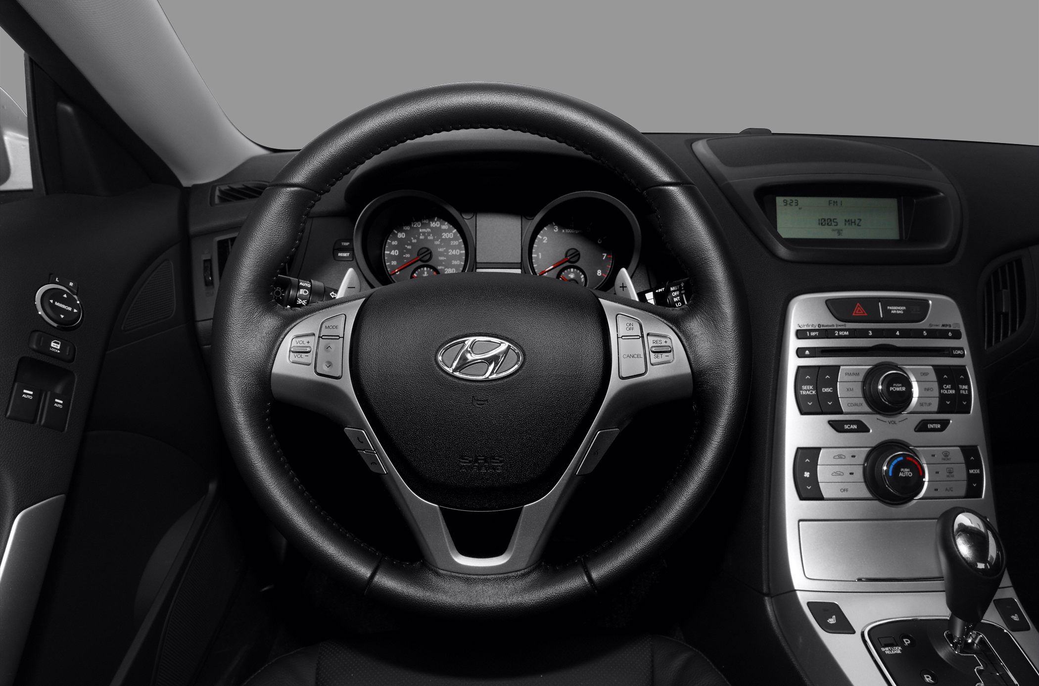 Steering wheel and central dashboard controls with instruments and gear shifter