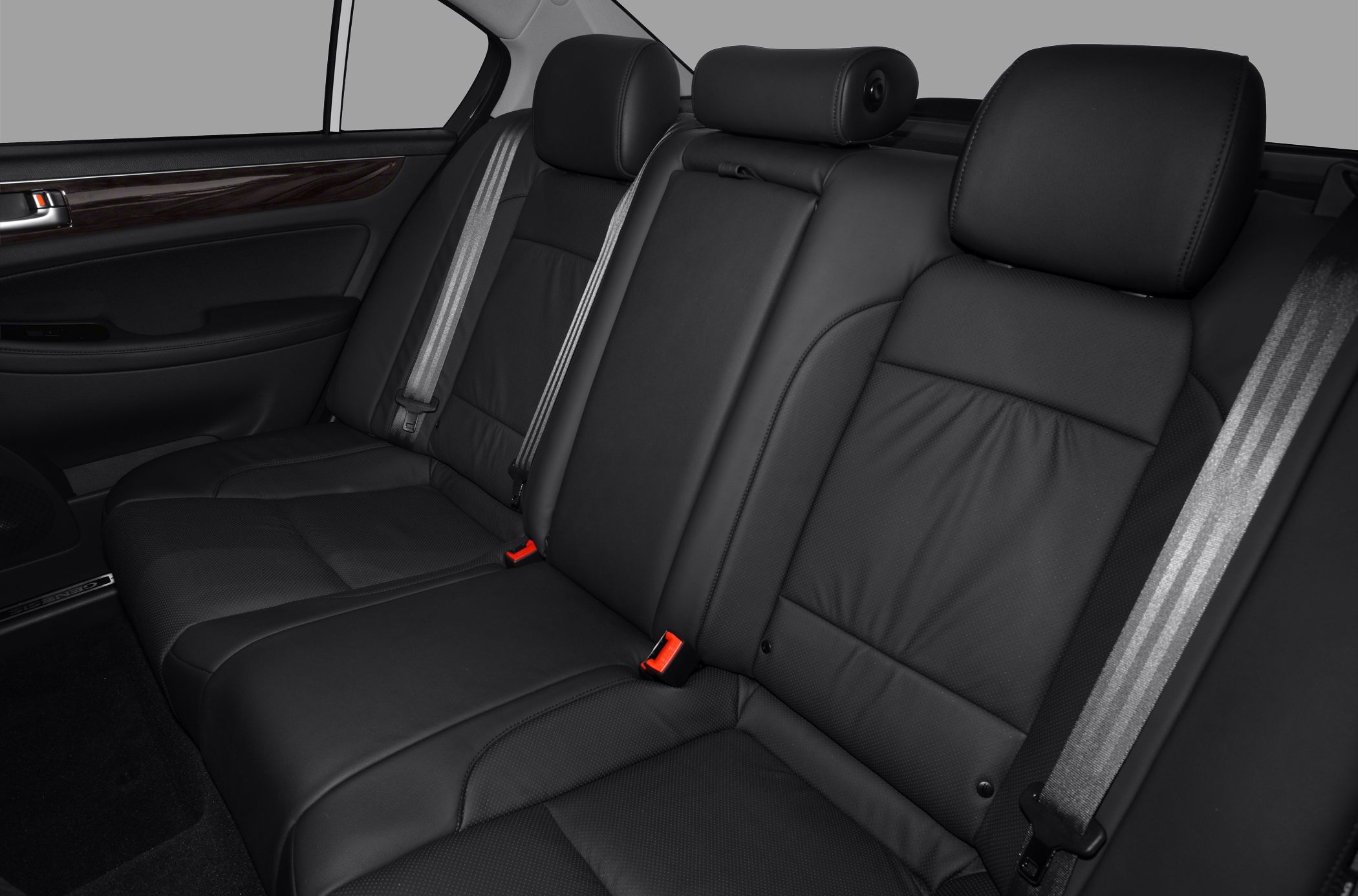 Rear seat interior with black leather upholstery, seat belts, and headrests