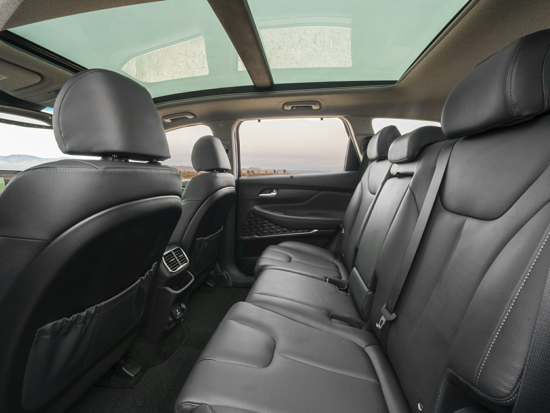Spacious rear cabin with black leather seats and panoramic glass roof