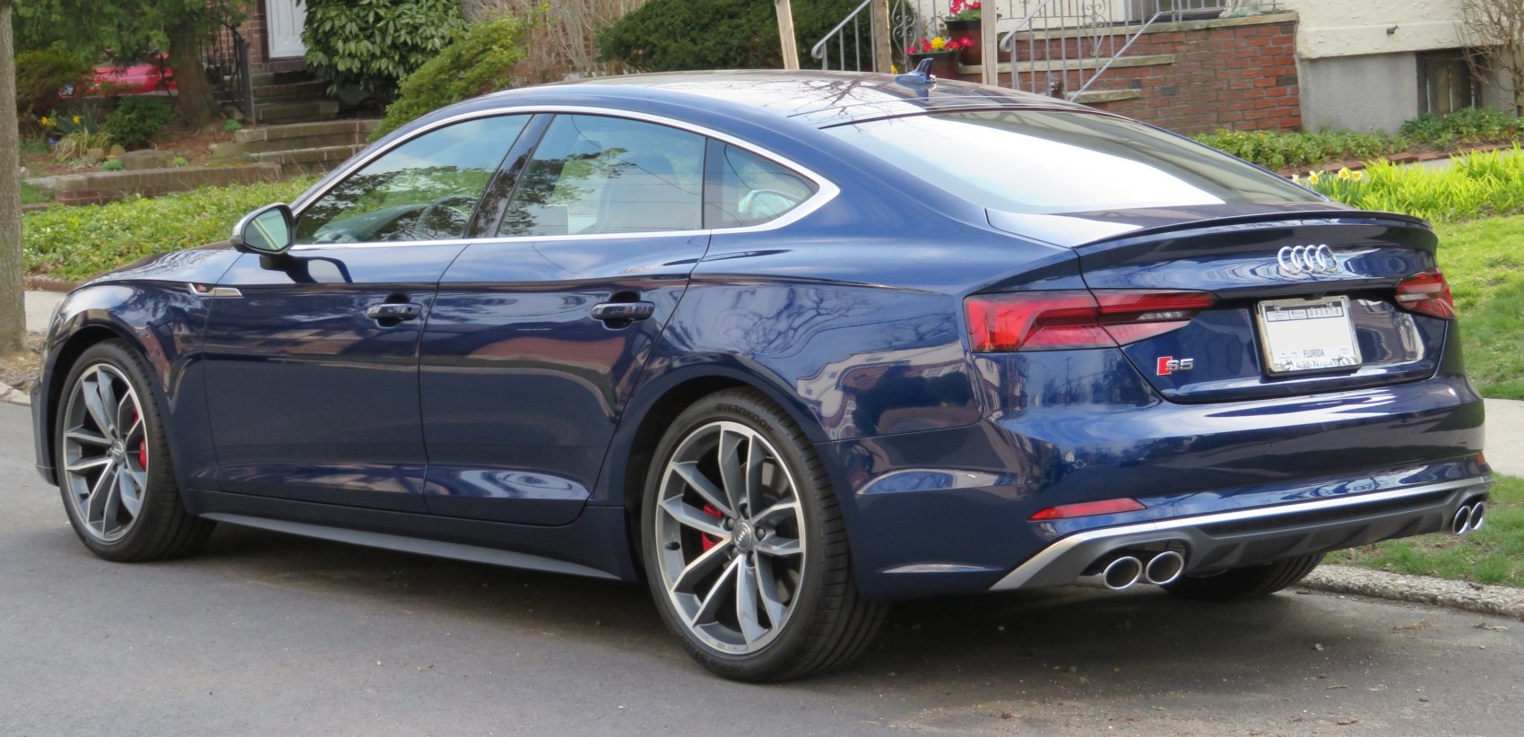Rear side view, quad exhausts, alloy wheels, sleek sedan silhouette