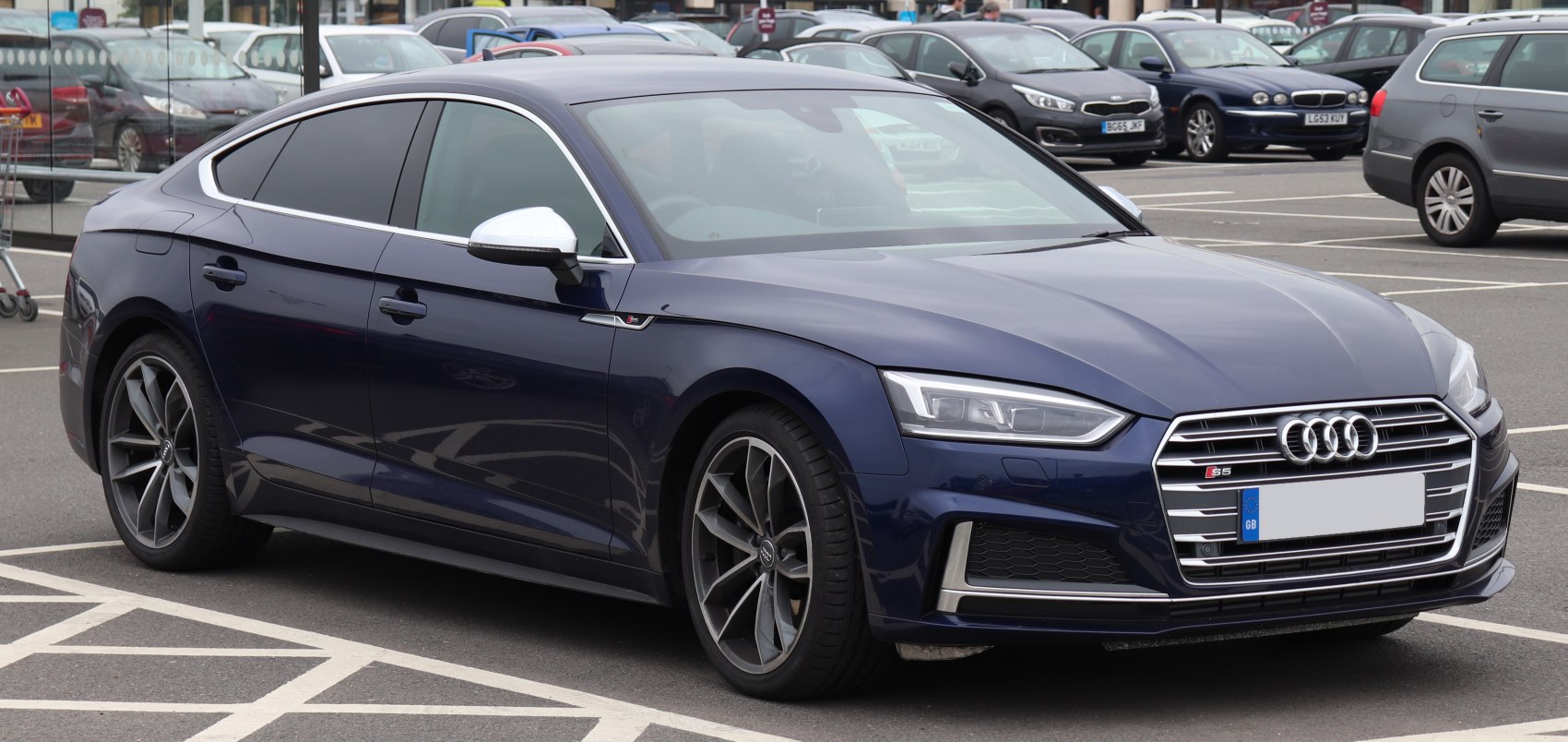 Front three-quarter view of a blue modern sedan with LED headlights and sporty alloy wheels
