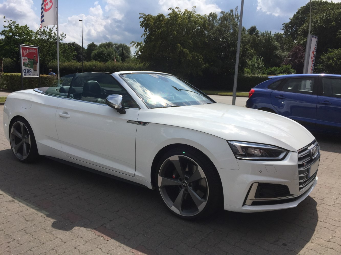 White convertible with sporty large alloy wheels and sharp headlight design
