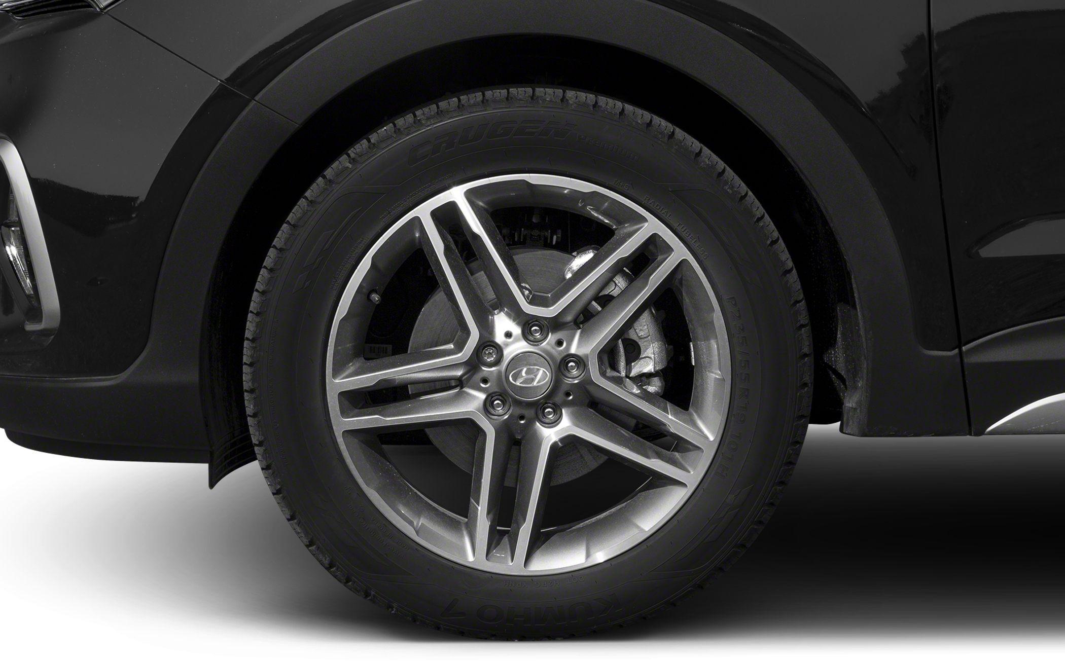 Alloy wheel with multi-spoke design and tire on black vehicle side.