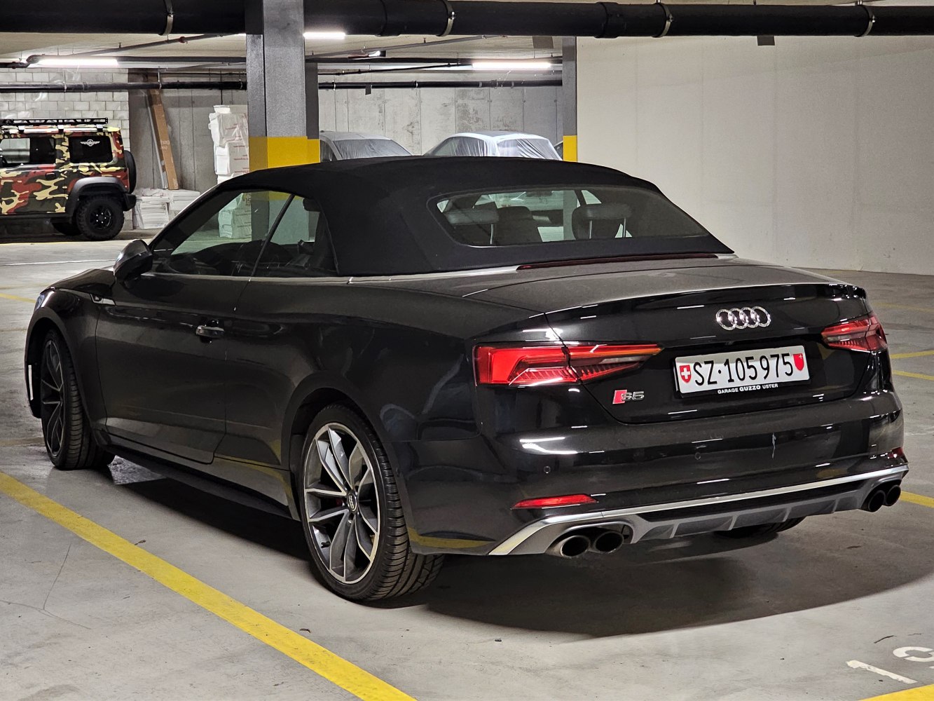 Rear view of convertible with closed soft top and quad exhausts.