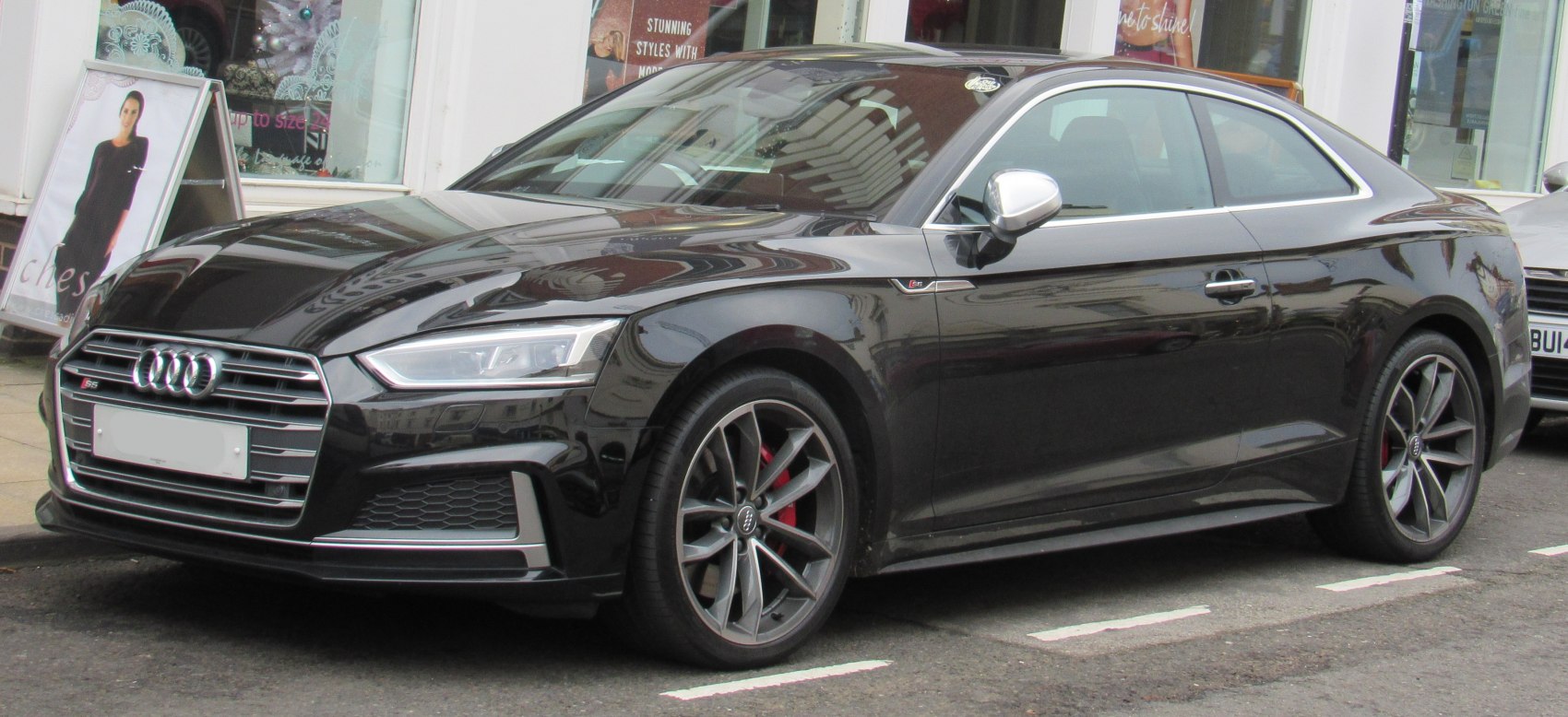 Front side view of black coupe with alloy wheels and LED headlights