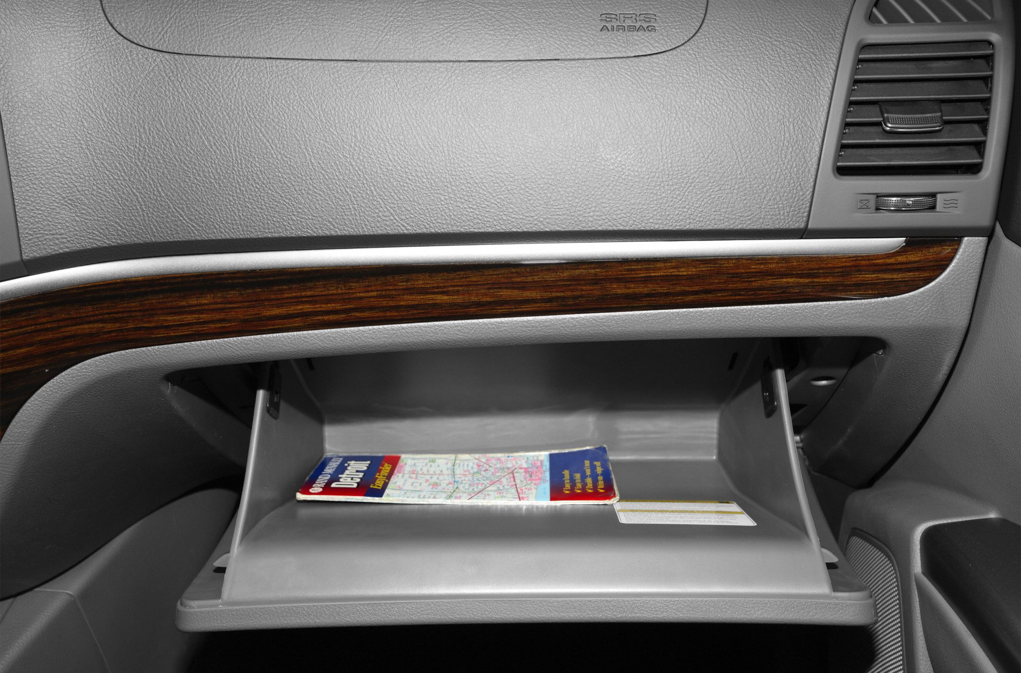 Open glove compartment with map and wood trim