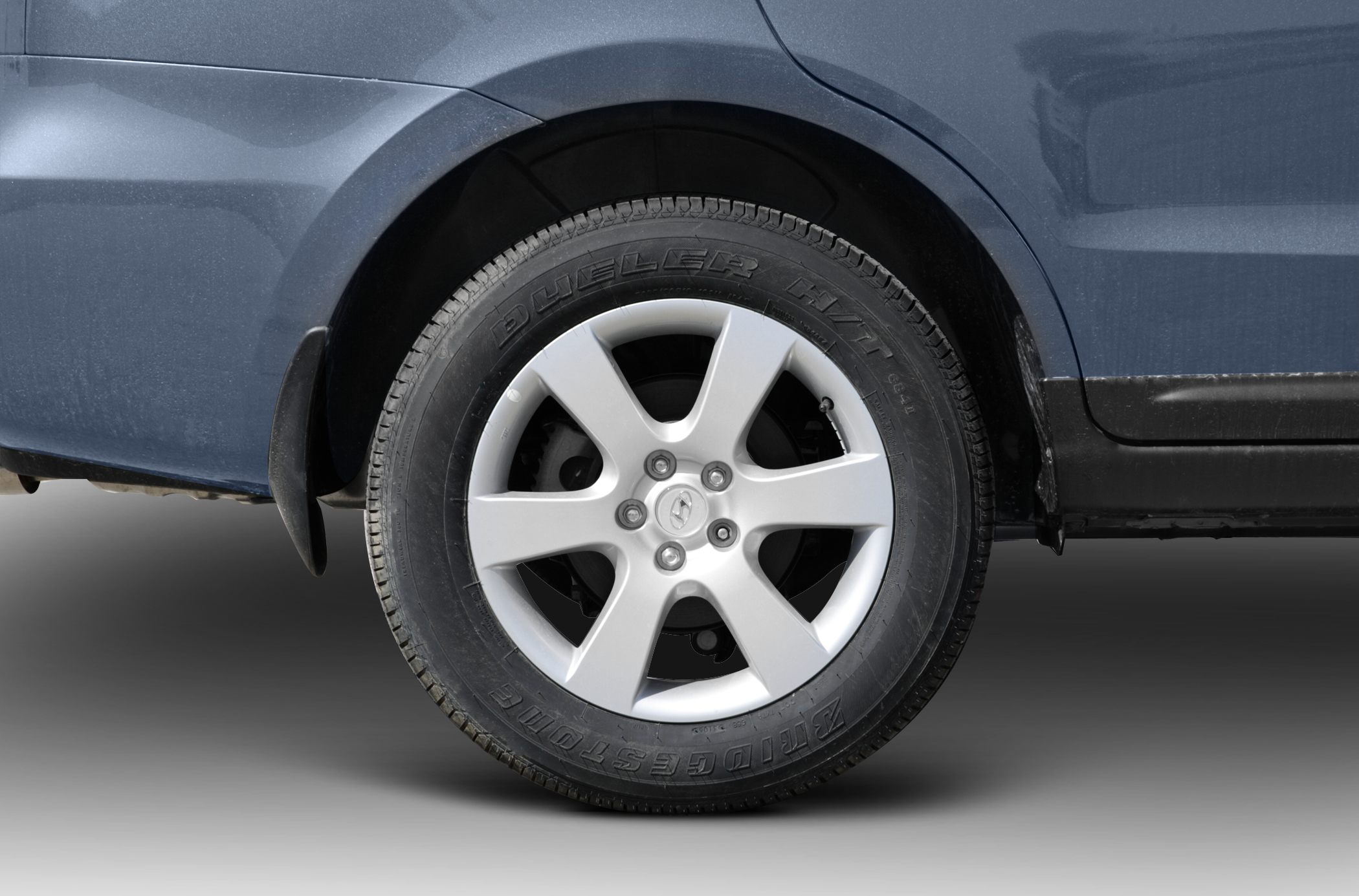 Alloy wheel with Bridgestone Dueler tire on dark vehicle side.