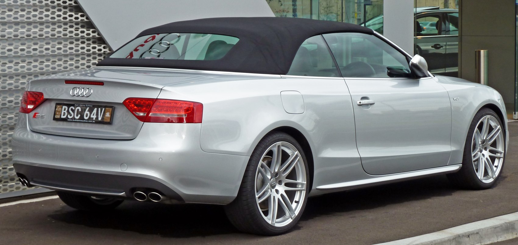 Rear side view of convertible with soft top and dual exhaust