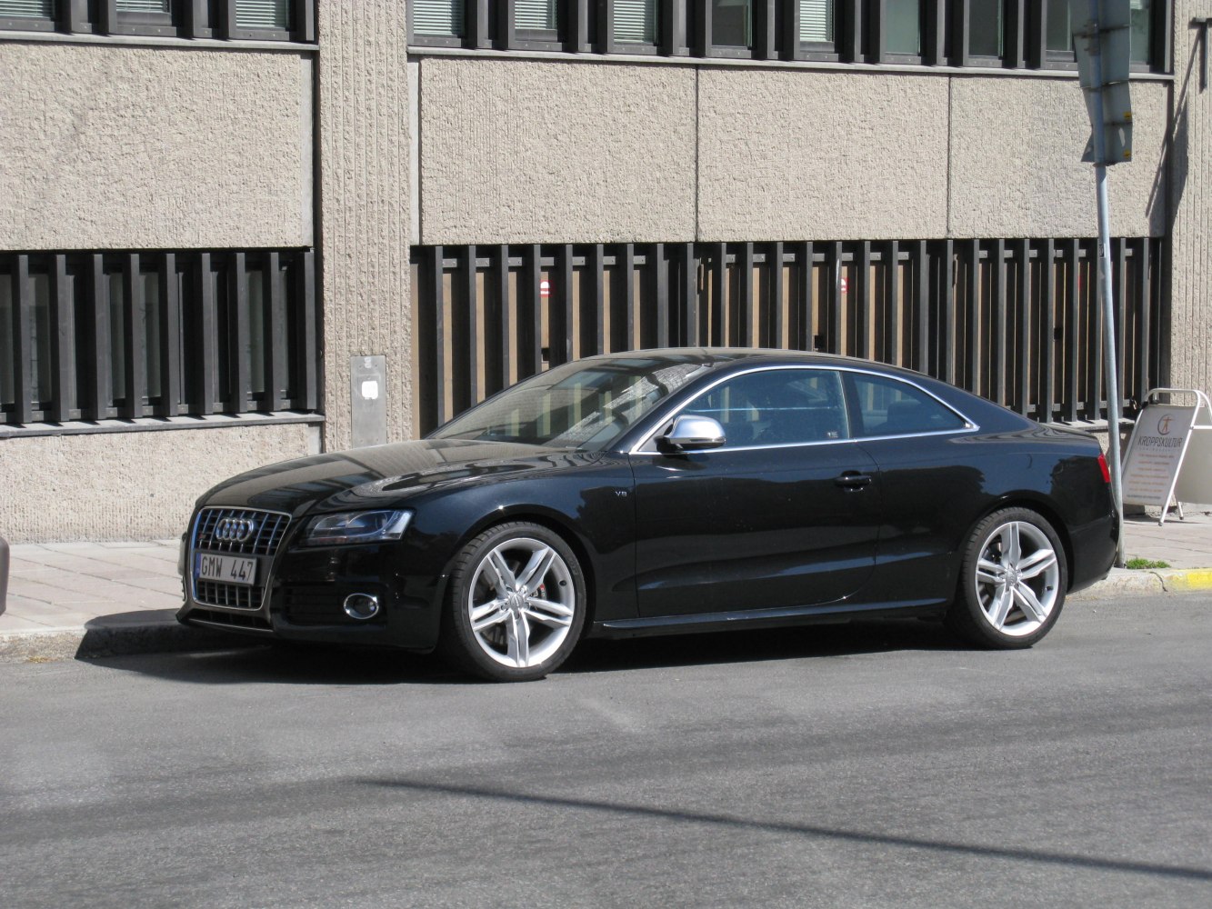 Black luxury coupe with V8 badge, sleek modern design