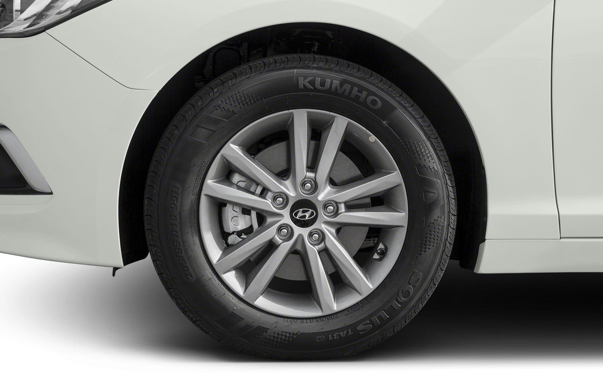 Close-up of alloy wheel and Kumho tire on white car