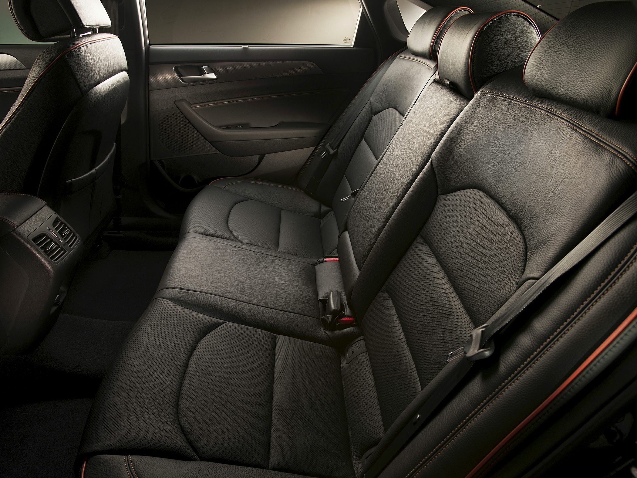 Rear black leather seats with contrast stitching and seatbelt details
